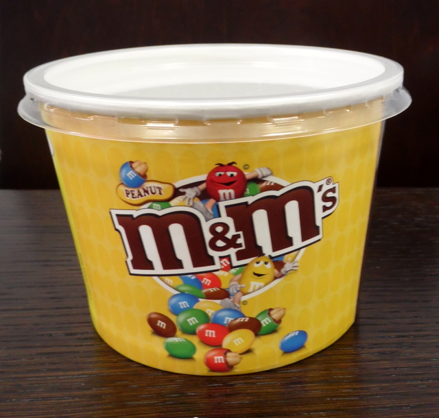 Muki kannella ja logolla M&M